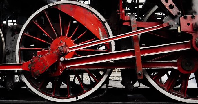 Close up shot steel red wheels of vintage steam train start turning