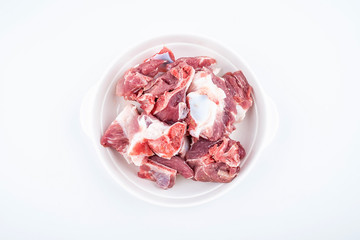 Fresh pork bones on a saucer on white background