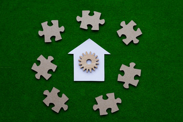 House, gear, puzzles on a green background. Real estate, shared ownership. market, purchase, sale of housing.