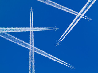 Several aircraft with white contrails