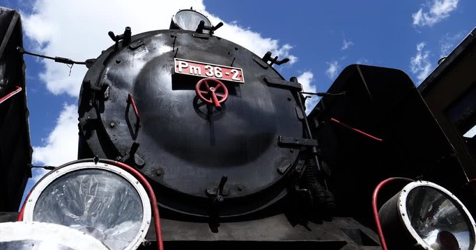 Time Lapse of vintage steam train front part with blue sky and clouds