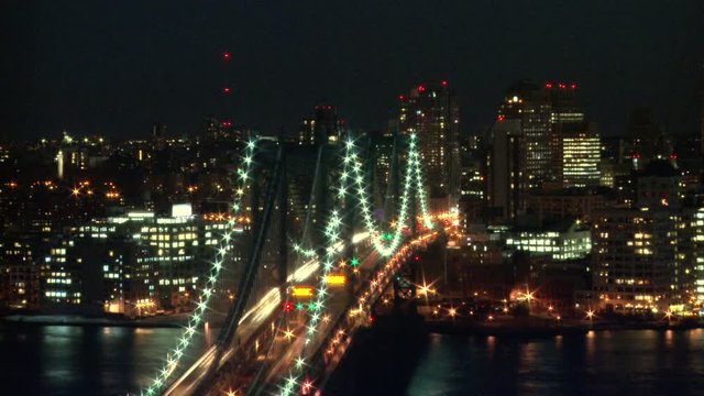 Modern city life time lapse of cars driving over a bridge, illuminated night city skyline, Long shot