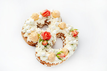 Obraz na płótnie Canvas number eight cake decorated with flowers, cream of cheese, marshmallow, Bizet on a white background. International Women's Day postcard March 8