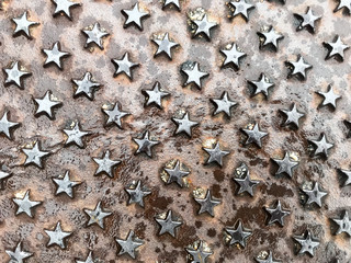 Iron stars shapes, color background, shabby metal, metal background, gradients with scratches, Overhead view of scratched grunge sheet of metal. Texture with light vignetting and wet look