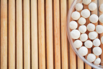 white round pepper in a round container on a texture background