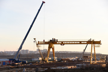 Mobile auto cranes and gantry crane working at construction site. Digging a pit for the building of an underground tunnel of the metro line. Subway construction project, Minsk, Belarus, Aerodromnaya
