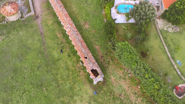 Tourists admiring the world's largest granary, horreo in Carnota. Aerial high angle tilting down establishing shot