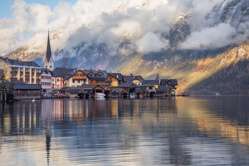 Obraz premium Hallstatt, urocza wioska nad jeziorem Hallstattersee i słynna atrakcja turystyczna, otoczona pięknymi górami, w regionie Salzkammergut w Austrii, w zimowy słoneczny dzień.