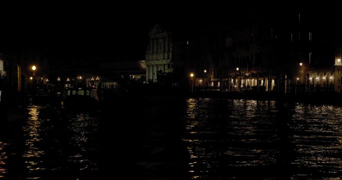 Night cityscape of Venice, Italy. Illuminated buildings reflecting in the Grand Canal. Santa Maria di Nazareth Church and Scalzi bridge in the distance.