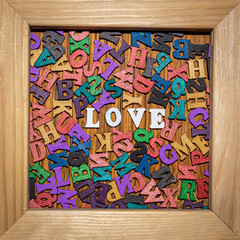 Inscription love made of wooden letters in a wooden frame