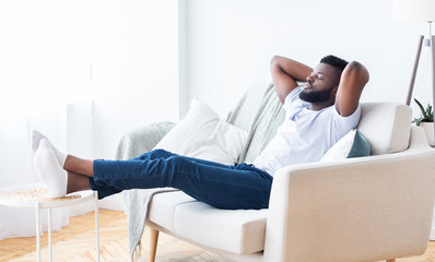 Young african american man relaxing at home, free space