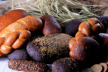 Fresh collection of bread and wheat on the table. Collection of different types of bread: White, rye, seed, form bread. lots of photos of bread with rye ears