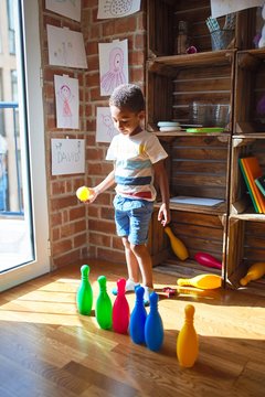 Beautiful african american toddler playing bowling at kindergarten