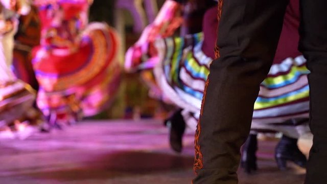 Stunning slow motion of Mexican dresses twirling as couples move in a folk dance.