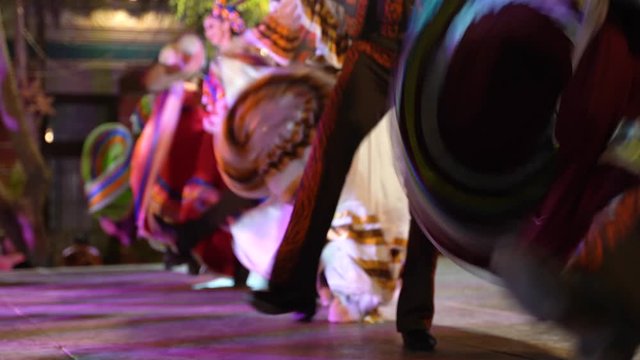 Women animate their dresses as men stomp the floor in this Mexican folk dance.