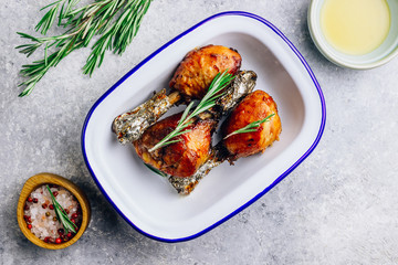 Grilled chicken drumstick bbq with rosemary on a stone gray background.