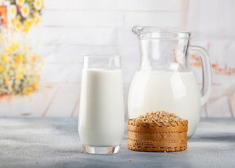Glass of vegan oat milk and Oat on a table, space for text.