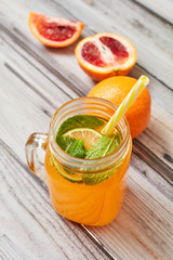 Fresh orange on a wooden background. Juice in a jar. Summer drink. Orange on a wooden background.