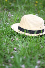 Straw hat on the green grass background