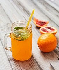 Fresh orange on a wooden background. Juice in a jar. Summer drink. Orange on a wooden background.