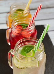 Summer drinks. Fresh freshes on a dark board. Orange, lemon and strawberry fresh.