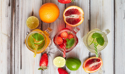Summer drinks. Fresh freshes on a wooden background. View from above. Orange, lemon and strawberry fresh.