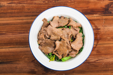 Boiled beef tongue with vegetables is served on a plate in a restaurant