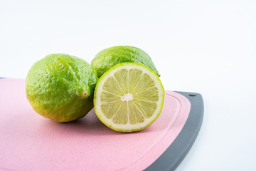 Fresh green lemon on red cutting board