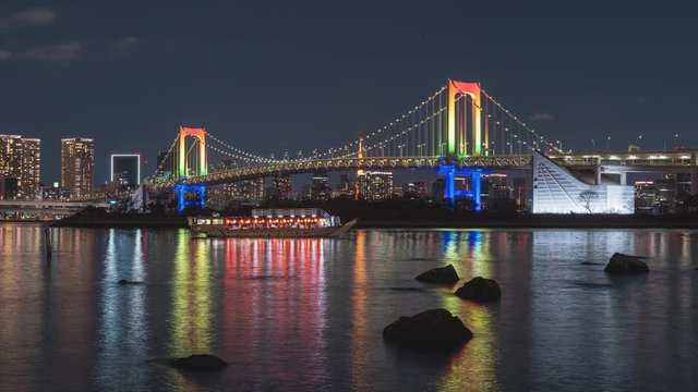 Odaiba Tokyo Rainbow Bridge at night with special light up reflection and boat