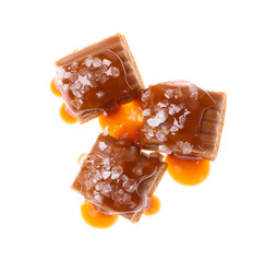 Delicious salted caramel with sauce on white background, top view