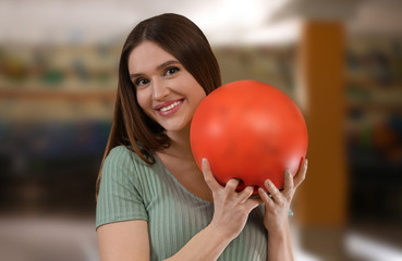 Fototapeta na wymiar Young woman with ball in bowling club