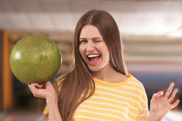 Fototapeta premium Young woman with ball in bowling club