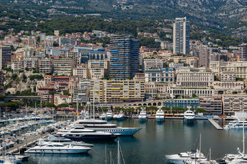 Marina of Monte Carlo In Monaco. Luxury yachts crowded into the Port Hercule, Monaco. Luxury buildings of the city in the background.