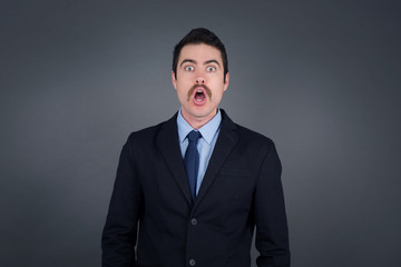 Attractive young man having stunned and shocked look, with mouth open and jaw dropped, listening to friend's story in full disbelief, exclaiming: Wow, I can't believe this. Surprised boy. Shock