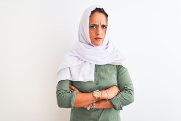 Young beautiful Arab woman wearing traditional Muslim hijab over isolated background skeptic and nervous, disapproving expression on face with crossed arms. Negative person.