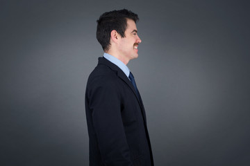 Profile of smiling businessman with healthy pure skin, has bushy hairstyle, has contemplative expression, ready to have outdoor walk, isolated over white studio wall with copy space