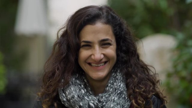 Young middle eastern lady staring happy and excited at the camera laughing and smiling with joy. outdoor. 4K