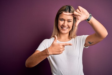 Young beautiful blonde woman wearing casual white t-shirt over purple isolated background smiling making frame with hands and fingers with happy face. Creativity and photography concept.