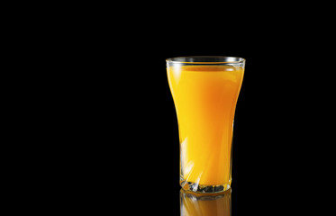 Orange juice glass on a black background