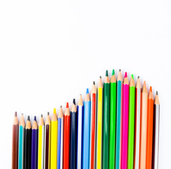 Colorful wood pencils arranged in a wave formation on a white background