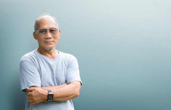 Happy Smiling Asian Senior Man With Arms Crossed Looking To Camera.