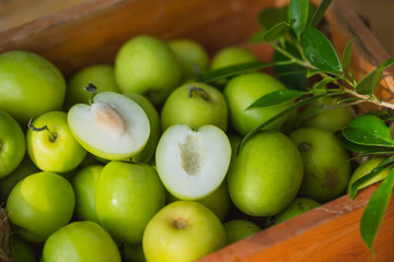 Indian jujubes in basket on table.Chinese date.Fresh jujubes. Fresh and delicious Indian jujube fruit with cut pulp. Jujube seed with wood background.