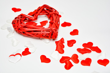 Red woven a large heart and small hearts of silk on a white background. Theme for Valentine's Day and holidays