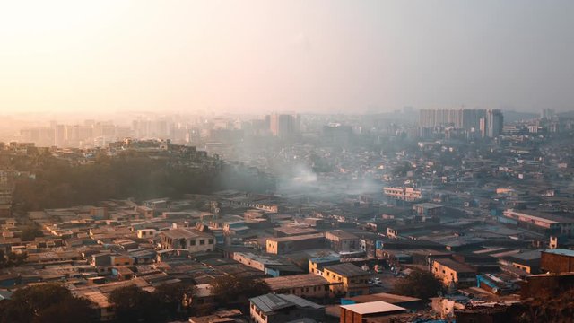 Timelapse of Smoke rising from Slum buildings at Sunset