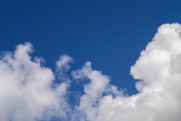 White cumulus clouds on blue sky.