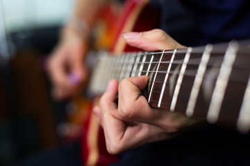 Fototapeta premium musician's hand is playing a red electric guitar in the recording room.