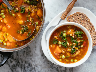 Home made Italian winter minestrone soup with winter squash, carrots, kale, green beans, peas, tomatoes and barley - obrazy, fototapety, plakaty