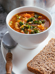 Home made Italian winter minestrone soup with winter squash, carrots, kale, green beans, peas,...