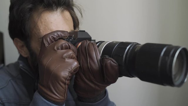 Tough private detective spying and stalking suspects while shooting photos with camera. 4K