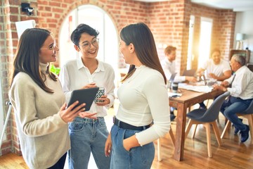 Business workers smiling happy. Standing with smile on face working together using tablet at the office